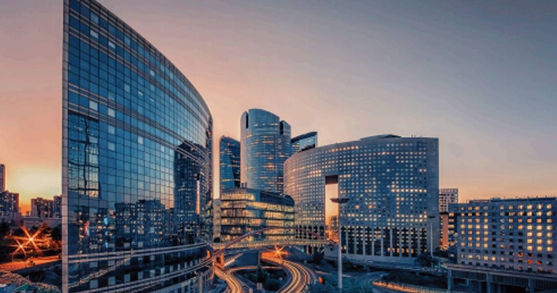 Group of high-rise commercial towers and a busy street during dusk